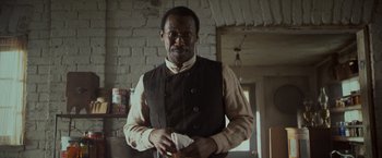 Movie still from “The Curious Case of Benjamin Button” (2008), directed by David Fincher – A man standing in front of a brick wall holding a napkin; Close Up shot, Low angle