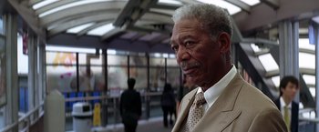 Movie still from “The Dark Knight” (2008), directed by Christopher Nolan – An older man wearing a suit and tie; Close Up shot, Low angle