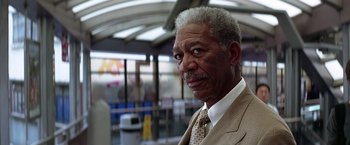 Movie still from “The Dark Knight” (2008), directed by Christopher Nolan – An older man wearing a suit and tie; Close Up shot, Low angle