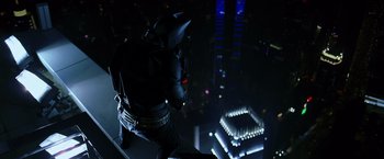 Movie still from “The Dark Knight” (2008), directed by Christopher Nolan – A man in a batman costume standing on a ledge; Wide shot, Overhead angle