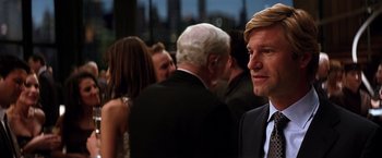 Movie still from “The Dark Knight” (2008), directed by Christopher Nolan – A group of people standing in a room; Close Up shot, Over the shoulder angle