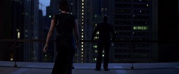 Movie still from “The Dark Knight” (2008), directed by Christopher Nolan – A man and a woman standing on a balcony at night; Wide shot, Over the shoulder angle