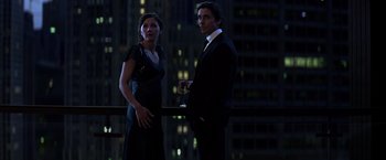 Movie still from “The Dark Knight” (2008), directed by Christopher Nolan – A man and a woman standing next to each other in front of a building; Medium shot, Low angle
