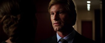 Movie still from “The Dark Knight” (2008), directed by Christopher Nolan – A person wearing a suit and tie; Close Up shot, Over the shoulder angle