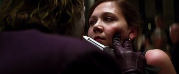 Movie still from “The Dark Knight” (2008), directed by Christopher Nolan – A woman holding a pair of scissors in front of her face; Close Up shot, Over the shoulder angle
