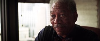 Movie still from “The Dark Knight” (2008), directed by Christopher Nolan – An older man with a beard and a mustache; Close Up shot, Over the shoulder angle