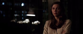 Movie still from “The Dark Knight” (2008), directed by Christopher Nolan – A woman with long dark brown hair looking at the camera; Close Up shot, Over the shoulder angle