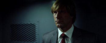 Movie still from “The Dark Knight” (2008), directed by Christopher Nolan – A person wearing a suit and tie; Close Up shot, Low angle