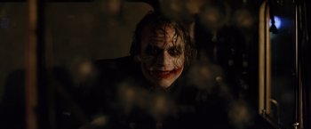 Movie still from “The Dark Knight” (2008), directed by Christopher Nolan – A person wearing a joker mask; Close Up shot, Over the shoulder angle