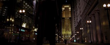 Movie still from “The Dark Knight” (2008), directed by Christopher Nolan – A person walking down a street at night; Extreme Wide shot, Low angle