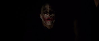 Movie still from “The Dark Knight” (2008), directed by Christopher Nolan – A man with a joker make - up on his face; Close Up shot, Low angle