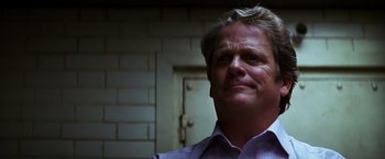 Movie still from “The Dark Knight” (2008), directed by Christopher Nolan – A person wearing a dress shirt; Close Up shot, Low angle