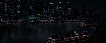 Movie still from “The Dark Knight” (2008), directed by Christopher Nolan – A boat floating on top of a body of water at night; Extreme Wide shot, High angle