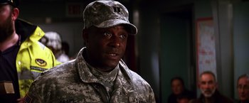 Movie still from “The Dark Knight” (2008), directed by Christopher Nolan – A man in a military uniform is looking at the camera; Close Up shot, Low angle