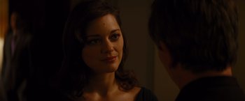 Movie still from “The Dark Knight Rises” (2012), directed by Christopher Nolan – A woman looking into a mirror while standing next to a man; Close Up shot, Over the shoulder angle