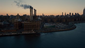 Movie still from “The Dark Knight Rises” (2012), directed by Christopher Nolan – An aerial view of a city with a river in front of it; Extreme Wide shot, High angle