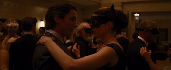 Movie still from “The Dark Knight Rises” (2012), directed by Christopher Nolan – A man and a woman dressed up in a masquerade mask; Close Up shot, Over the shoulder angle
