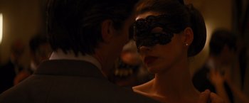 Movie still from “The Dark Knight Rises” (2012), directed by Christopher Nolan – A woman wearing a black lace mask and a man wearing a white shirt; Close Up shot, Over the shoulder angle