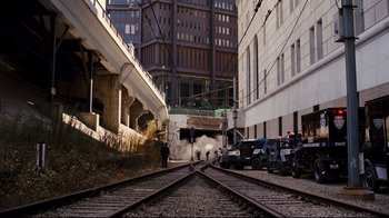 Movie still from “The Dark Knight Rises” (2012), directed by Christopher Nolan – A couple of people standing next to some train tracks; Extreme Wide shot, High angle