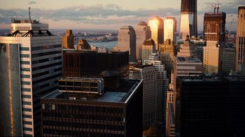 Movie still from “The Dark Knight Rises” (2012), directed by Christopher Nolan – The sun is setting over a large city; Extreme Wide shot, High angle