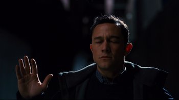 Movie still from “The Dark Knight Rises” (2012), directed by Christopher Nolan – A man with his eyes closed and his hand raised; Close Up shot, High angle