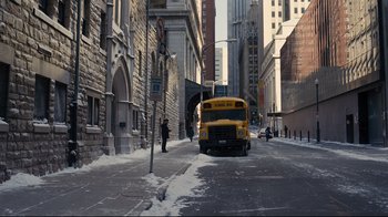 Movie still from “The Dark Knight Rises” (2012), directed by Christopher Nolan – A school bus is parked on the side of the street; Extreme Wide shot, High angle