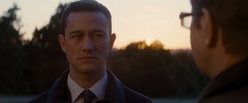 Movie still from “The Dark Knight Rises” (2012), directed by Christopher Nolan – A person wearing a suit and tie; Close Up shot, Over the shoulder angle