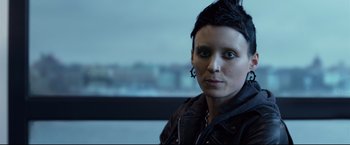 Movie still from “The Girl with the Dragon Tattoo” (2011), directed by David Fincher – A woman with a black jacket and a black star on her forehead; Close Up shot, Low angle