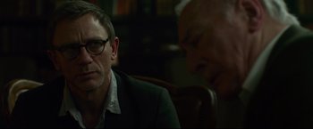 Movie still from “The Girl with the Dragon Tattoo” (2011), directed by David Fincher – A man wearing glasses and a suit sitting next to another man in a suit; Close Up shot, Over the shoulder angle
