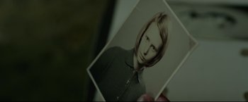 Movie still from “The Girl with the Dragon Tattoo” (2011), directed by David Fincher – A person holding a picture of a woman; Extreme Close Up shot, High angle