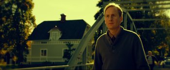 Movie still from “The Girl with the Dragon Tattoo” (2011), directed by David Fincher – A man standing in front of a house; Medium shot, Low angle