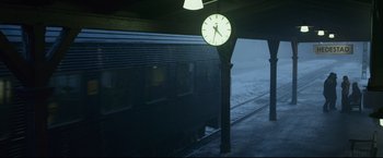 Movie still from “The Girl with the Dragon Tattoo” (2011), directed by David Fincher – A clock on the side of a train platform at night; Extreme Wide shot, High angle