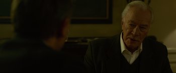 Movie still from “The Girl with the Dragon Tattoo” (2011), directed by David Fincher – A man wearing a suit and tie sitting in front of another man wearing a suit; Close Up shot, Over the shoulder angle