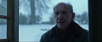 Movie still from “The Girl with the Dragon Tattoo” (2011), directed by David Fincher – An older man in a black jacket is looking at the camera; Close Up shot, Over the shoulder angle