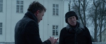 Movie still from “The Girl with the Dragon Tattoo” (2011), directed by David Fincher – Two men standing in front of each other and one is holding a cell phone; Medium shot, Over the shoulder angle