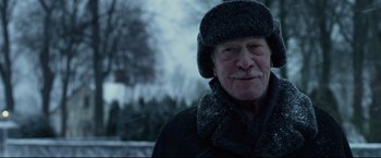Movie still from “The Girl with the Dragon Tattoo” (2011), directed by David Fincher – An older man wearing a hat and a scarf; Close Up shot, Over the shoulder angle
