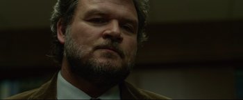 Movie still from “The Girl with the Dragon Tattoo” (2011), directed by David Fincher – A person wearing a suit and tie; Close Up shot, Low angle