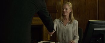 Movie still from “The Girl with the Dragon Tattoo” (2011), directed by David Fincher – A woman in a white shirt is shaking a man's hand; Medium shot, Over the shoulder angle