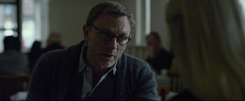Movie still from “The Girl with the Dragon Tattoo” (2011), directed by David Fincher – A person wearing glasses and a sweater; Close Up shot, Over the shoulder angle