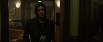 Movie still from “The Girl with the Dragon Tattoo” (2011), directed by David Fincher – A man in a black jacket is standing in a room; Close Up shot, Low angle