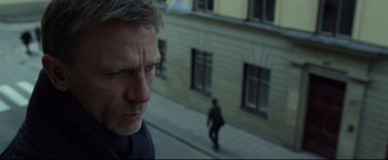 Movie still from “The Girl with the Dragon Tattoo” (2011), directed by David Fincher – A person walking on a sidewalk near a building; Close Up shot, Over the shoulder angle