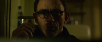 Movie still from “The Girl with the Dragon Tattoo” (2011), directed by David Fincher – A person wearing glasses; Close Up shot, Low angle