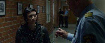 Movie still from “The Girl with the Dragon Tattoo” (2011), directed by David Fincher – A man is pointing to something on a woman's face; Close Up shot, Over the shoulder angle