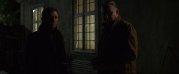 Movie still from “The Girl with the Dragon Tattoo” (2011), directed by David Fincher – Two men standing next to each other near a window; Medium shot, Over the shoulder angle
