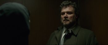 Movie still from “The Girl with the Dragon Tattoo” (2011), directed by David Fincher – A person wearing a suit and tie; Close Up shot, Low angle