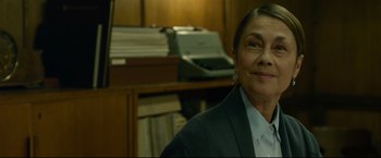 Movie still from “The Girl with the Dragon Tattoo” (2011), directed by David Fincher – A woman in a suit and tie in front of a desk; Close Up shot, Over the shoulder angle