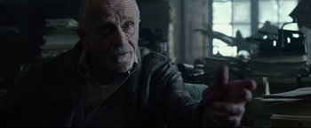 Movie still from “The Girl with the Dragon Tattoo” (2011), directed by David Fincher – An older man sitting on a couch looking at a cell phone; Close Up shot, Low angle