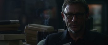Movie still from “The Girl with the Dragon Tattoo” (2011), directed by David Fincher – A man wearing glasses sitting in front of a window; Close Up shot, Over the shoulder angle
