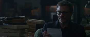 Movie still from “The Girl with the Dragon Tattoo” (2011), directed by David Fincher – A man sitting in a chair holding a piece of paper; Close Up shot, Over the shoulder angle