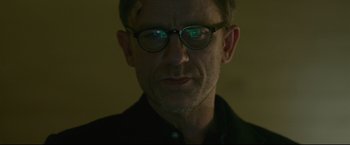 Movie still from “The Girl with the Dragon Tattoo” (2011), directed by David Fincher – A person wearing glasses and a black shirt; Close Up shot, Low angle